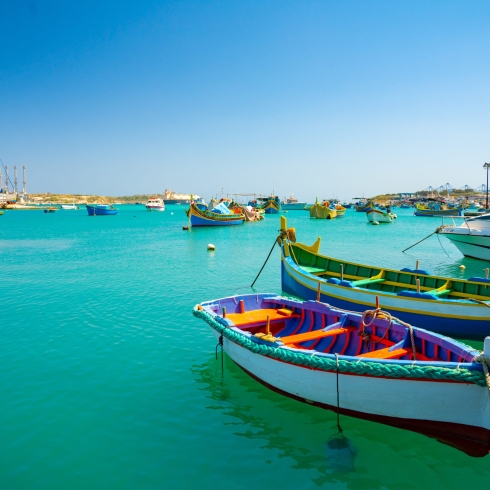 A view of traditional fishing boats luzzu in the Marsaxlokk Harbor in Malta